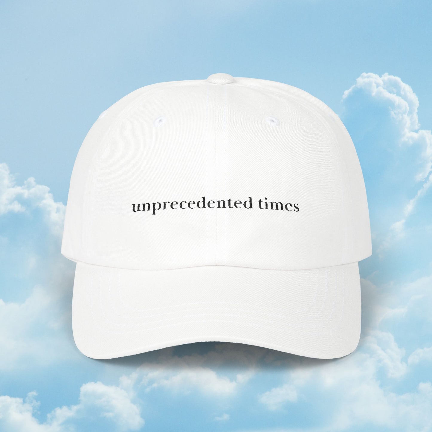 White cap with 'unprecedented times' text against a blue sky background