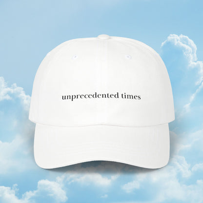 White cap with 'unprecedented times' text against a blue sky background