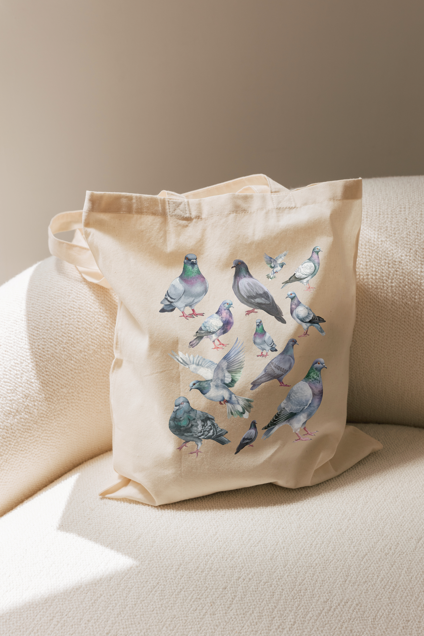 Beige tote bag with bird illustrations on a beige couch